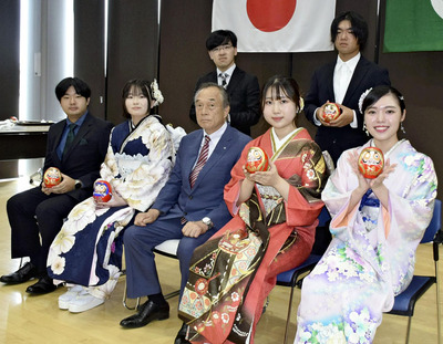 記念品の双葉ダルマを手に古里に思いをはせ、決意を新たにする出席者＝双葉町産業交流センター