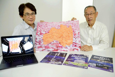 宇宙から帰還したポスターを手にする長谷川代表理事（左）と甚野顧問。画面内は宇宙空間に漂うポスターの様子