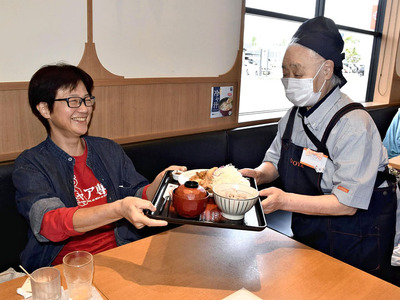来店客が注文した料理を配膳する高齢者（右）