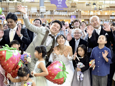 町民らに囲まれ、学び舎ゆめの森で結婚式を挙げた沖野さんと遠藤さん（中央）＝大熊町