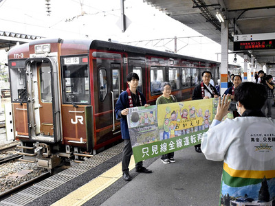 ＪＲ会津若松駅で車両と記念撮影する乗客ら＝１日、会津若松市