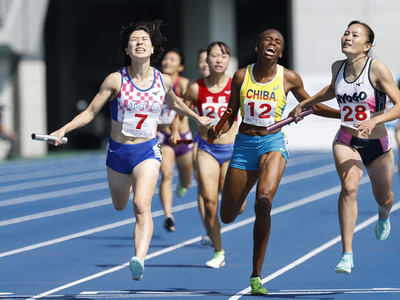 国スポの陸上成年少年男女混合１６００メートルリレー決勝で３チーム混戦のレースを制し、１位でゴールする松本奈菜子（左）（東邦銀行）＝平和堂ＨＡＴＯスタジアム