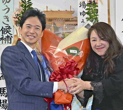 初当選を決め、支援者から花束を受ける馬場氏（左）。ＳＮＳなどで幅広い層から支持を集めた＝１６日