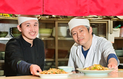 調理した料理を差し出す晃さん（右）と圭司さん。親子で初代の味を受け継いでいる