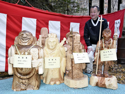 布袋、弁財天、寿老人、毘沙門天などの木像と清家さん。「まち歩きを通じて幸せになってほしい」と願う＝６日午後、浅川町
