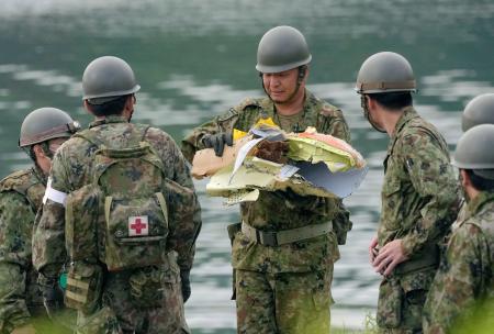 　自衛隊員によって回収された航空自衛隊Ｔ４練習機の破片とみられる物＝１５日午前５時５３分、愛知県犬山市