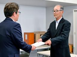 　岡山県側に原因究明などを求める要望書を手渡す、住民団体代表の小倉博司さん（右）＝１５日午後、岡山県庁