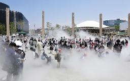 　ミストを浴びる来場者＝１３日、大阪市此花区の夢洲