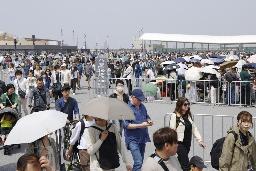 　大阪メトロ夢洲駅（右奥）を利用して万博会場に向かう人たち＝４月、大阪市此花区の夢洲