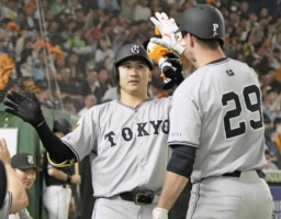　４回、本塁打を放ち、グリフィン（右）に迎えられる巨人・泉口＝東京ドーム