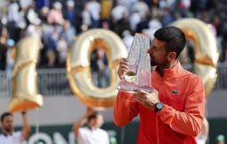 　ジュネーブ・オープンの男子シングルス決勝で優勝して通算１００勝を達成し、トロフィーにキスするジョコビッチ＝２４日（ロイター＝共同）