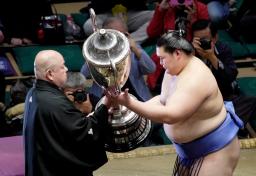 　大相撲夏場所で２場所連続優勝し、日本相撲協会の八角理事長（左）から賜杯を受け取る大の里＝２５日、東京・両国国技館