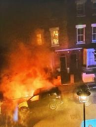 　８日、ロンドンの路上で炎上する車。スターマー英首相がかつて所有していた（住民提供・共同）