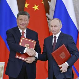 　共同声明に署名し握手する中国の習近平国家主席（左）とロシアのプーチン大統領＝８日、モスクワ（新華社＝共同）