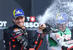 　英国ＧＰで今季初勝利を挙げ、シャンパンファイトを楽しむアプリリアのマルコ・ベゼッチ＝２５日、シルバーストーン（ロイター＝共同）