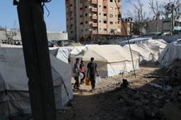 　破壊された学校の敷地内で避難生活を送るパレスチナ人ら＝２５日、ガザ中部デールバラハ（ゲッティ＝共同）