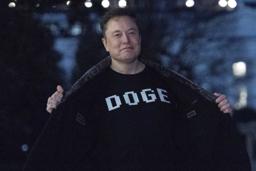 　政府効率化省を意味する「ＤＯＧＥ」の文字が書かれたＴシャツを見せるマスク氏＝３月、ワシントン（ＡＰ＝共同）