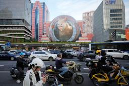 　中国上海市内でバイクに乗る人たち＝２０日（共同）