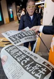 　元巨人の長嶋茂雄さん死去を伝える号外を受け取る人＝３日午前９時５４分、ＪＲ有楽町駅前