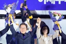　韓国大統領選で当選を確実にし、支持者の前で花束を掲げる「共に民主党」の李在明前代表（左）＝４日未明、ソウルの国会前（共同）