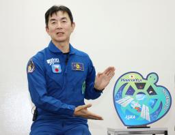　記者会見するＪＡＸＡの油井亀美也飛行士。右はウミガメをかたどった国際宇宙ステーション滞在ミッションのロゴマーク＝４日午後、東京都千代田区