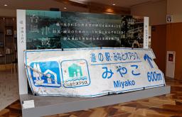 　「市災害資料伝承館」に展示されている東日本大震災の津波でねじまがった道の駅の案内標識＝岩手県宮古市
