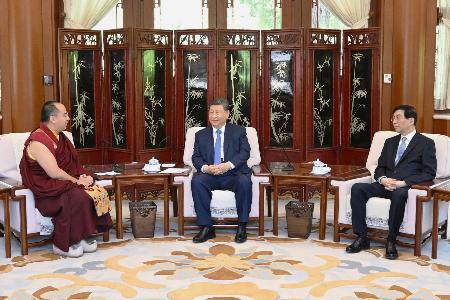 　中国政府公認のチベット仏教指導者、パンチェン・ラマ１１世（左）と面会する習近平国家主席（中央）＝６日、北京の中南海（新華社＝共同）