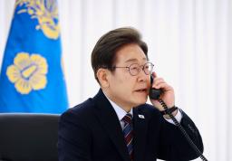 　米国のトランプ大統領との電話会談のため、受話器を持つ韓国の李在明大統領＝６日、ソウル（聯合＝共同）