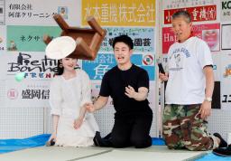 　「第１７回ちゃぶ台がえし世界大会」でちゃぶ台をひっくり返す参加者（中央）＝７日午後、岩手県矢巾町