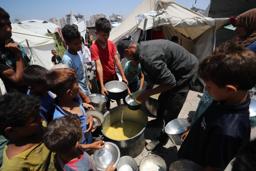 　パレスチナ自治区ガザ北部ガザ市で、慈善団体から食料を受け取る人々＝１１日（ゲッティ＝共同）