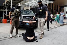 　不法移民摘発を巡る抗議デモで座り込む人＝１２日、米シカゴ（ロイター＝共同）