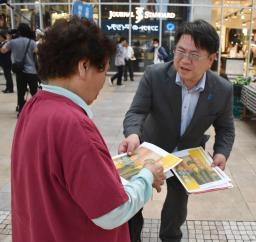 　拉致被害者の松木薫さんの早期帰国に向けて署名を呼びかける弟の信宏さん（右）＝１３日午後、熊本市中央区