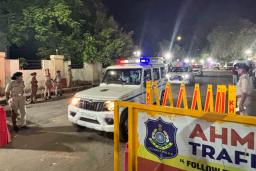 　旅客機が墜落した現場近くを通る緊急車両＝１３日、インド西部アーメダバード（共同）