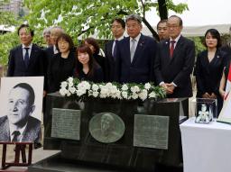 　マルセル・ジュノー博士の顕彰碑前で開かれた贈呈式後、記念撮影する松井一実広島市長（右から２人目）ら＝１５日午前、広島市中区