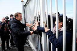 　グリーンランド・ヌークの空港で住民らと握手するフランスのマクロン大統領（左）＝１５日（Ｒｉｔｚａｕ　Ｓｃａｎｐｉｘ／Ｍａｄｓ　Ｃｌａｕｓ　Ｒａｓｍｕｓｓｅｎ提供、ロイター＝共同）