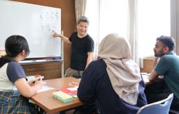 　岡山市の日本語教室でボランティアとして教える浦上幹生さん＝５月