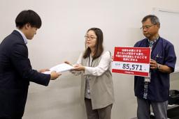 　厚労省の担当者に署名を提出する大藤朋子さん（中央）＝１８日午前、参院議員会館