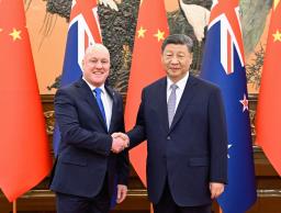 　握手するニュージーランドのラクソン首相（左）と中国の習近平国家主席＝２０日、北京の人民大会堂（新華社＝共同）