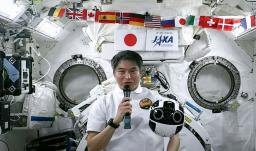 　２０日、国際宇宙ステーションで記者会見する大西卓哉飛行士。手前右に浮いているのは船内撮影用ロボット「イントボール２」（ＪＡＸＡの中継から）