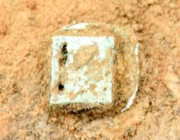 　出土した青銅製のベルト飾り「巡方」＝４月、長野市の南宮遺跡内（同市埋蔵文化財センター提供）