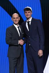 　ドラフト会議でマーベリックスから全体１位指名を受け、ＮＢＡのシルバー・コミッショナー（左）と握手するデューク大のフラッグ＝２５日、ニューヨーク（ゲッティ＝共同）