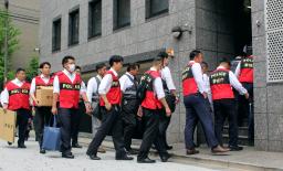 　指定暴力団住吉会の本部事務所へ家宅捜索に入る、警視庁と千葉県警の捜査員ら＝２６日午前、東京都港区