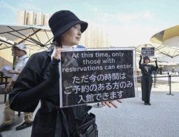 　入館のためには事前予約が必要になることを伝える日本館のスタッフ＝２日午後、大阪市此花区の夢洲