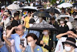 　梅雨明けしたとみられる名古屋市で、日傘を差して街頭演説を聞く人たち＝４日午後