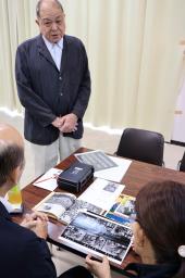 　鹿児島県奄美市に寄贈した写真データについて説明する民俗写真家の故芳賀日出男さんの長男日向さん＝３日、奄美市