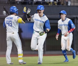 　７回、勝ち越し２ランを放ち次打者水野（左）とタッチを交わす日本ハム・清宮幸。右は五十幡＝エスコンフィールド