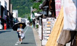 　猛暑日となった岐阜県美濃市で日傘を差す児童＝７日午後