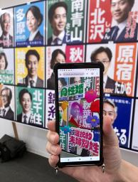 　選挙ポスターにスマートフォンのカメラをかざすと法制化に賛成の候補かどうかが分かるシステム。架空の候補者のポスターを使って報道陣に公開された＝６月、東京都渋谷区