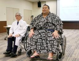 　体重３００キロまで対応できる超特大の車いす（右）に試乗する現役最重量の三段目出羽ノ城さん＝１１日午前、名古屋市