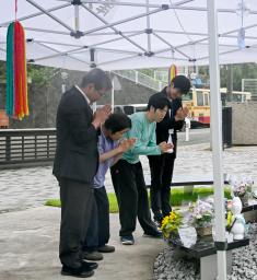 　津久井やまゆり園の献花式で、花を手向け手を合わせる入所者と職員＝１１日午前、相模原市
